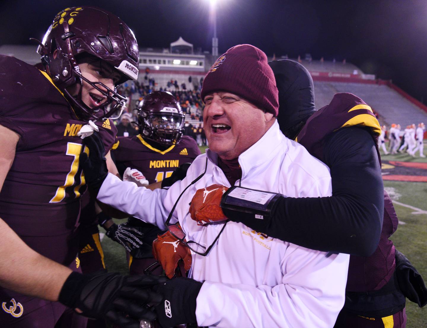 Montini head coach Mike Bukovsky, right, celebrates the Broncos’ 47-33 victory over Rochester with players including Angelo DeSensi during the IHSA Class 4A state championship game on Friday, Nov. 28, 2025 in Normal.