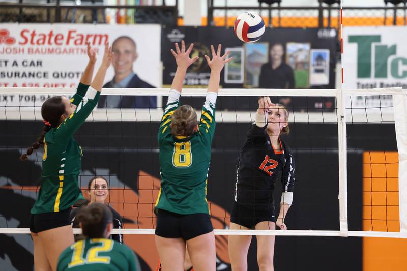 Beecher's Elena Kvasnicka spikes the ball over Grant Park's Camryn Karstensen, center, during the Bobcats' victory in two sets, 25-22, 25-23, over Grant Park in the RVC championship game on Monday, Oct. 20, 2025, at Beecher High School.