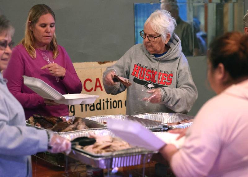 Volunteers serve up the food Wednesday, Nov. 26, 2025, during A World of Thanks, Community Thanksgiving hosted by DeKalb Mutual Aid at the McCabe’s building in DeKalb.