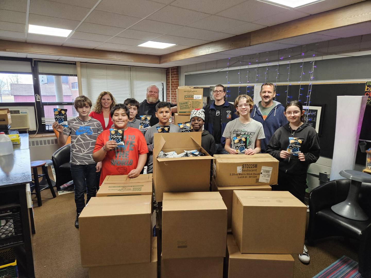 Students in St. Anne School District stand with boxes of Cares Closet donations from the local nonprofit Let's Ketchup in February 2025.