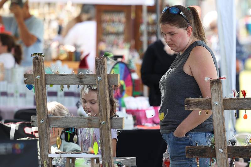 Jamie Allard and her daughter Alina browse a business tent at the Crest Hill Lions Luau and Car Show on Sunday, Sept. 1, 2024 in Crest Hill.