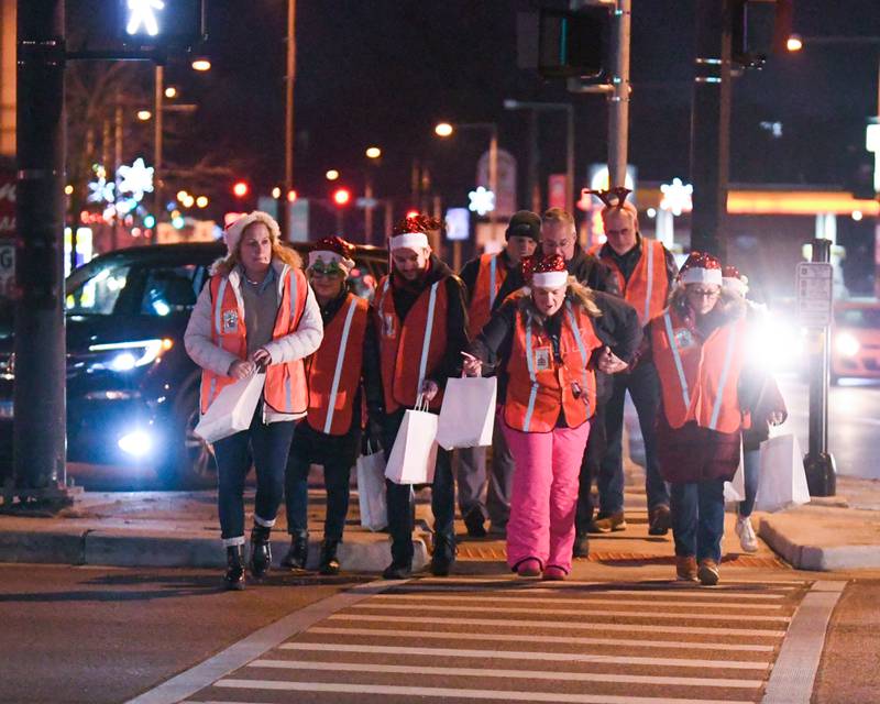 Members of the DeKalb Chamber of Commerce walk the parade route and hand out candy canes during the DeKalb Chamber of Commerce's annual Lights on Lincoln and Santa Comes to Town event held in downtown DeKalb on Thursday, Nov. 30, 2023.