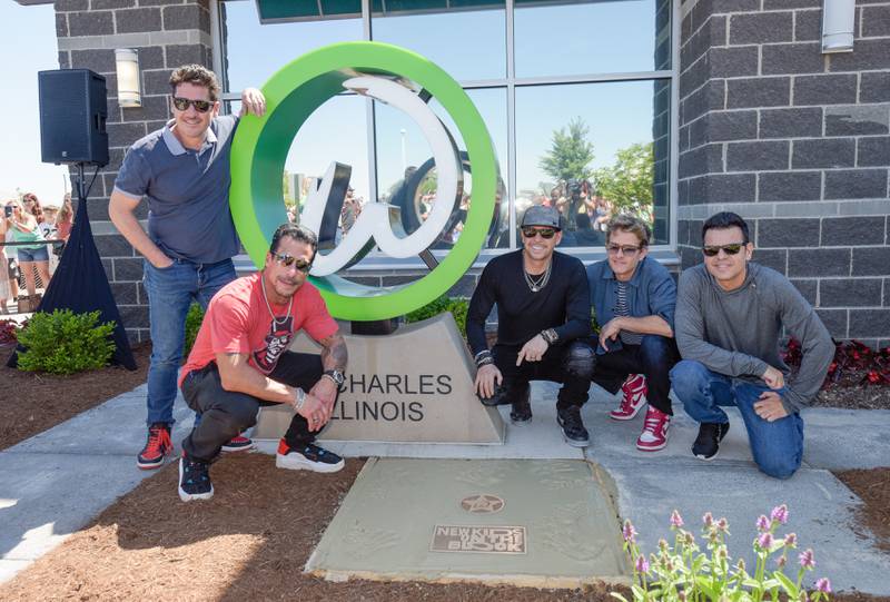 New Kids on the Block band members Jonathan Knight, Danny Wood, Donnie Wahlberg, Joey McIntyre and Jordan Knight (L-R) pose for a photo in front of the Wahlk of Fame at the Wahlburgers in St. Charles on Saturday, June 18, 2022.