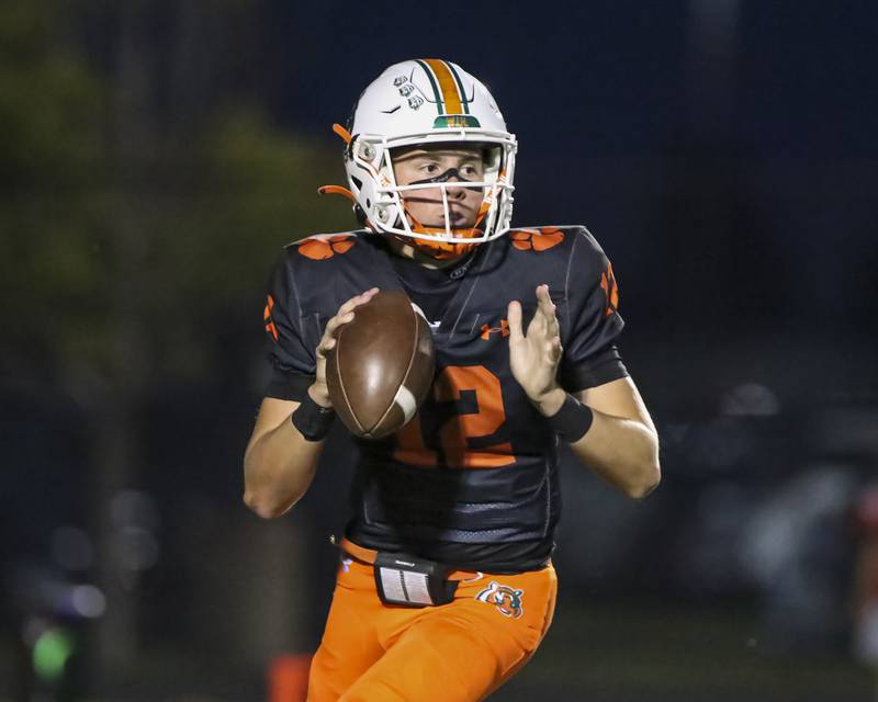 Plainfield East's Brady Cloherty (12) looks for an open receiver during football game between Yorkville at Plainfield East Friday, Sept 19, 2025 in Plainfield.