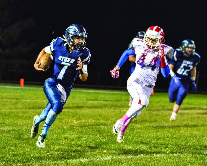 Bureau Valley quarterback Drake Davis (left) runs the ball while Morrison's Jarrett Ruchotzke prepares to try to tackle Davis during Friday night's game in Manlius.