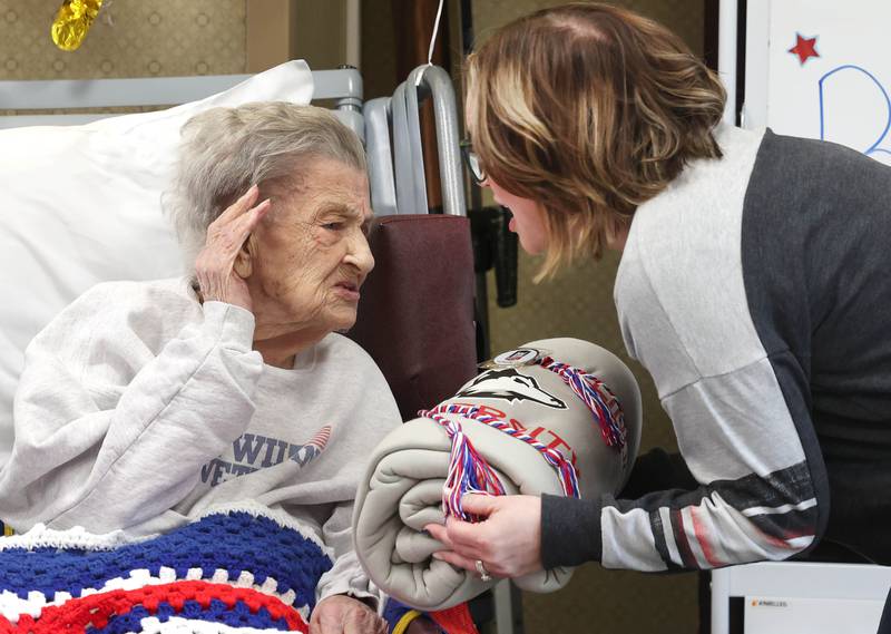 World War II veteran Myrtle Annetta Lusiak leans in to hear better Thursday, May 2, 2024, as she is presented with a gift from the Northern Illinois University Veterans Club during her birthday celebration at Aperion Care in DeKalb. Lusiak, who turned 107-years-old, was honored by DeKalb officials, veterans and other local groups Thursday for her service in the Women’s Army Corps from Aug. 5, 1943 until her honorable discharge on Nov. 27, 1945.