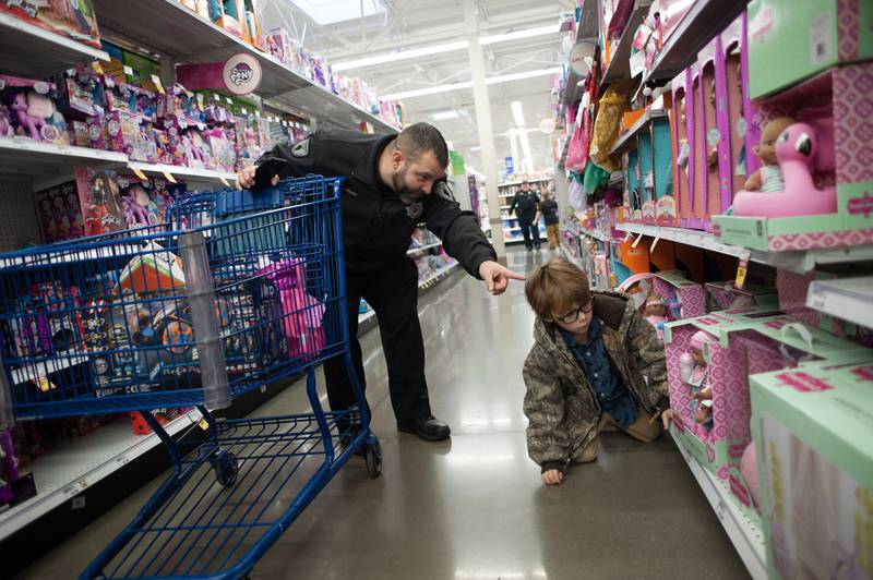 Bourbonnais Police Department Detective Jason Franc points out a toy to Ellis Perkins, 6, of Momence, during the annual Shop with a Cop at the Bradley Meijer in 2022. The village of Bourbonnais is accepting Shop with a Cop monetary donations through Friday.
