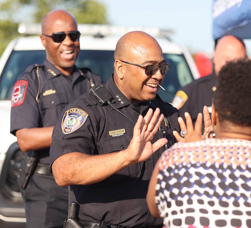 DeKalb Police Chief David Byrd (front) and Northern Illinois Police Chief Darren Mitchell greet visitors Tuesday, Aug. 2, 2022, during National Night Out in the parking lot of the Walmart on Sycamore Road in DeKalb.