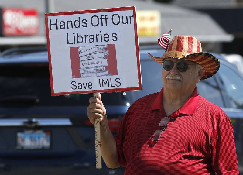 Tony Casalino of Woodstock protests along Route 31 in front of the McHenry Public Library on Friday, June 20, 2025, during a Save Our Libraries Protest hosted by Indivisible McHenry County to draw attention to cuts to the nation’s libraries by the Trump administration.