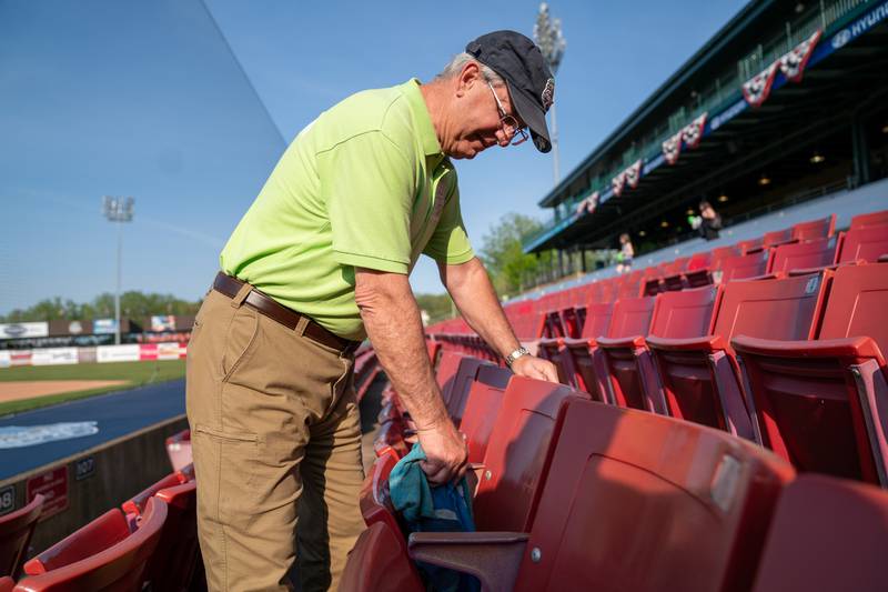 Sean King for the Daily Herald
Kane County Cougars Usher Mark Allen of St. Charles wipes down seats in preparation for opening day at Northwestern Medicine Field in Geneva on Friday, May 13, 2022.