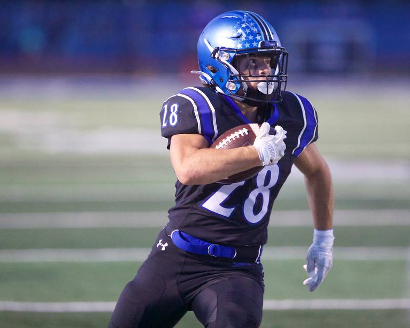 St. Charles North's Carsen Durante carries the ball for a gain against Geneva on Sept. 12, 2025 in St. Charles.