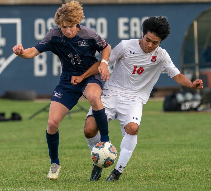 Oswego’s Killyan Avila (10) challenges Oswego East's Caleb Pankiewicz (11) for the ball during a soccer match at Oswego East High School on Monday, Sep 26, 2022.