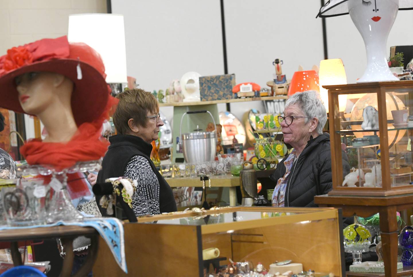 Linda Dunphy of Dixon (left) and Susie Lendman of Sterling chat as they look at antiques in Tammy Mendoza's booth at the Oregon Woman's Club Antique Show on Saturday in Oregon. Mendoza's antique shop 'The Cottage' is located in Coal Valley.