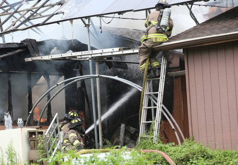 Firefighters work the scene of a fully-engulfed structure fire in the 500 block of North 2782nd Road on Monday, July 21, 2025 in La Salle. FIre departments from Utica, Wallace, Naplate, Spring Valley, Mendota, Troy Grove, La Salle, Peru, Oglesby and Tonica responded to the scene. Fire crews were dispatched at 9:45 a.m. La Salle Police and La Salle County Sheriff were also on the scene.