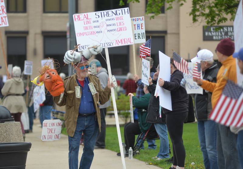 May Day Rally attendees carry signs on Thursday, May 1, 2025 around the historic Ogle County Courthouse in Oregon.