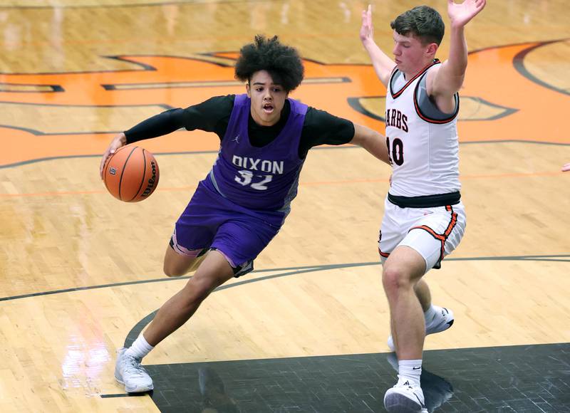 Dixon’s Darius Harrington drives by DeKalb’s Eric Rosenow during their game Tuesday, Dec. 12, 2023, at DeKalb High School.