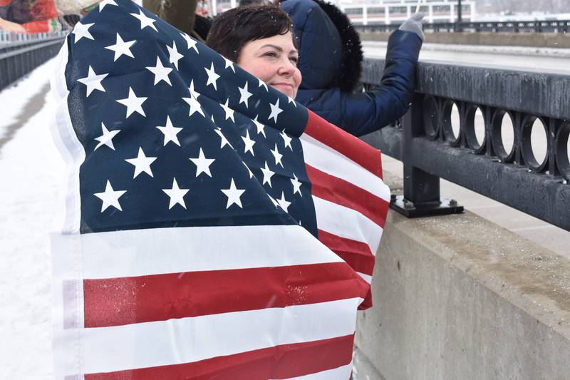 Jeanne Jailor of Rock Falls, holds up an American flag during a protest Saturday, Feb. 15, 2025, on the First Avenue bridge between Sterling and Rock Falls.