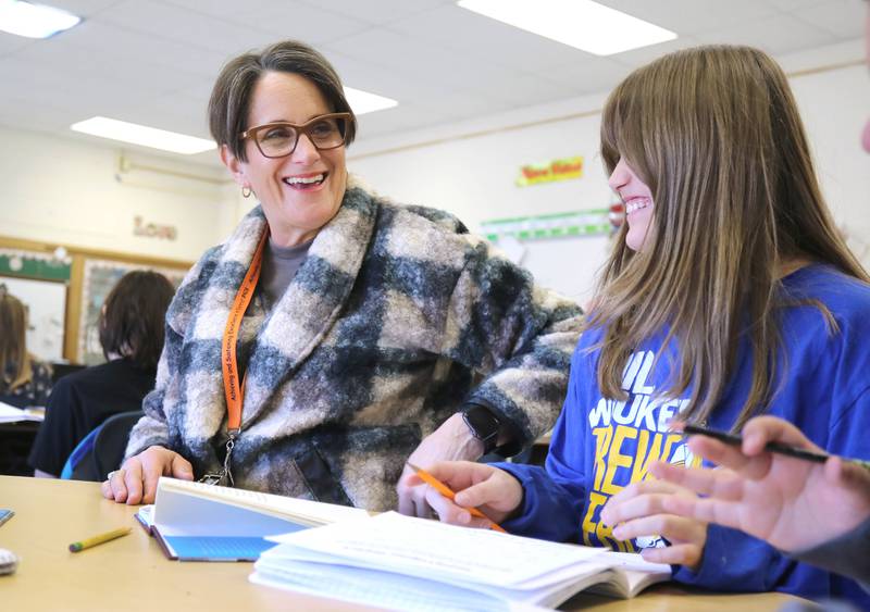 Mary Lynn Buckner, longtime educator at Littlejohn Elementary School, has a laugh with a student as she supports Nicole Schmidt's fifth-grade class during their individual work time Tuesday, March 14, 2023, at the school in DeKalb.