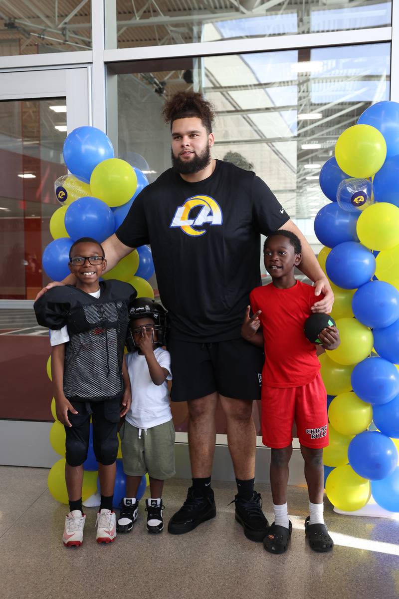 Keagen Trost, a 2019 Kankakee High School grad, poses with young fans during a celebration held for him at the school on May 4, 2026, following him being drafted into the NFL to the Los Angeles Rams. Pictured from left are Ayden Brantley, 8, Makari Hammond, 4, and Marquon Hammond Jr., 8, all of Kankakee.
