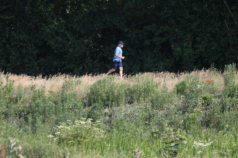 A jogger runs along Old Plank Road Trail on Friday, June 23, 2023 in Frankfort.