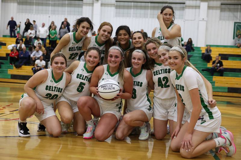 Providence team poses with Annalise Pietrzyk and her commemorative ball marking her 1,000th career points during the game against Minooka in the WJOL Basketball Tournament on Wednesday.