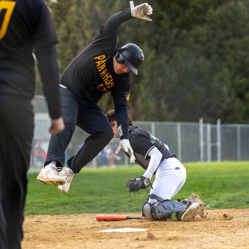Cameron Spralding (17) of Putnam County jumps to avoid being tagged out on Thursday, April 17, 2025 at Woodland High School in Streator.
