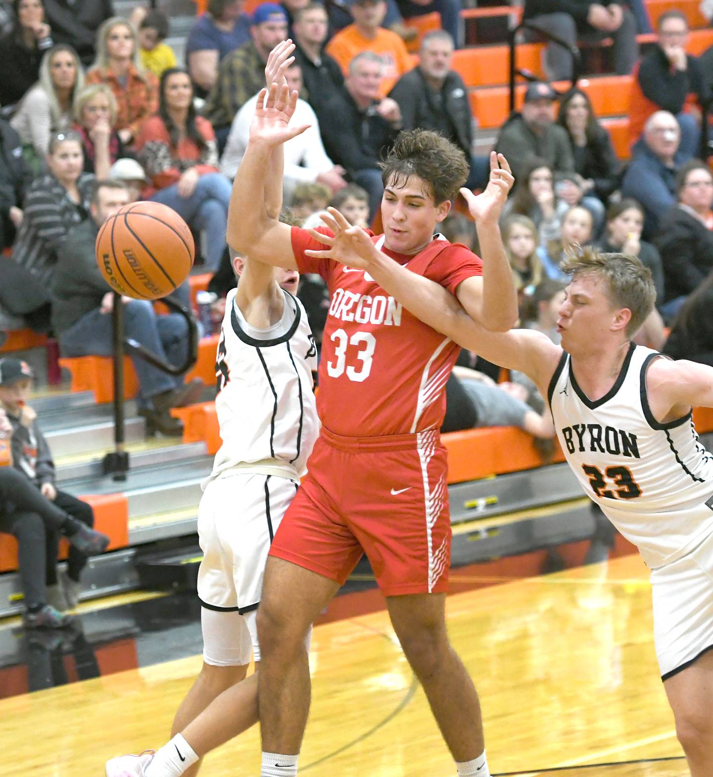 Oregon's Anthony Bell (33) and Byron's Braylon Kilduff (23) reach for a loose ball  on Friday, Jan. 20.