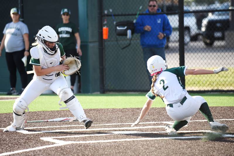 Bishop McNamara's Bridget Bertrand, left, gathers a late throw to home plate as Coal City's Madi Petersen slides in for a run during the Class 2A Coal City Regional championship Friday, May 23, 2025.