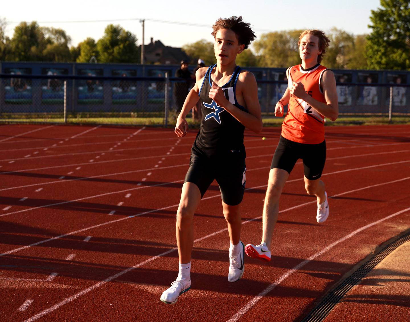 St. Charles North’s Samuel Hill and Kaneland’s Evan Nosek compete in the 3200-meter run during the Kane County boys track and field championships on Friday, May 9, 2025 at St. Charles North.
