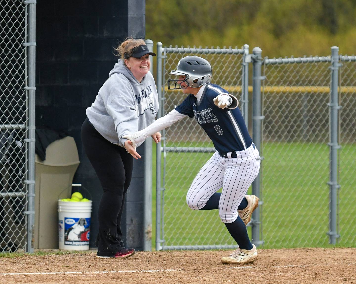 Oswego East's Danielle Stone, right, gets congratulated by her coach after hitting a home run during the game on Thursday April 17, 2025, while taking on Plainfield North held at Oswego East.