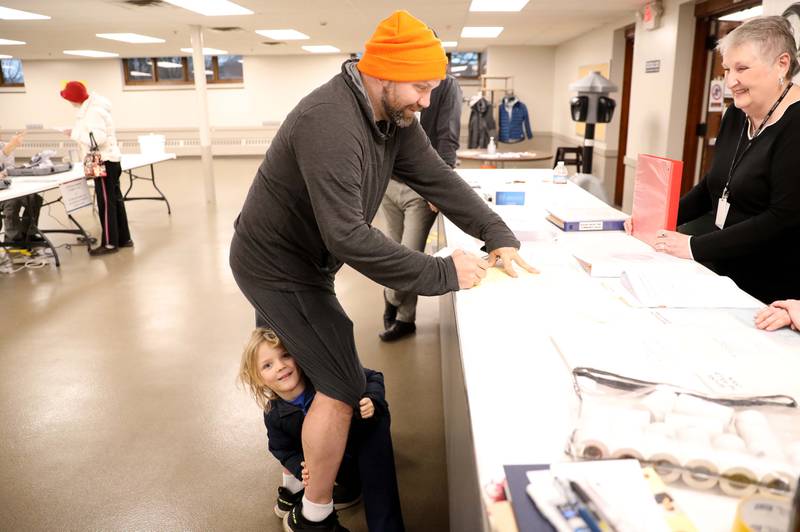 Chris Forberg, with his son, Dean, 4, gets help with some forms from election judge Pearl Tabbert during the Consolidated Election on Tuesday, April 4, 2023 at the Sugar Grove Township Community Center.