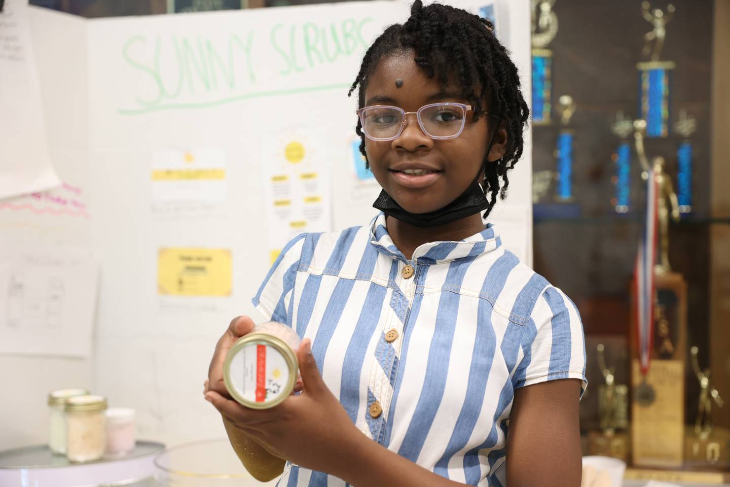 Ava Martin holds up a sugar based facial scrub from her Sunny Scrub business at the Laraway 70C 5th Grade Business Expo. Friday, May 13, 2022, in Joliet.