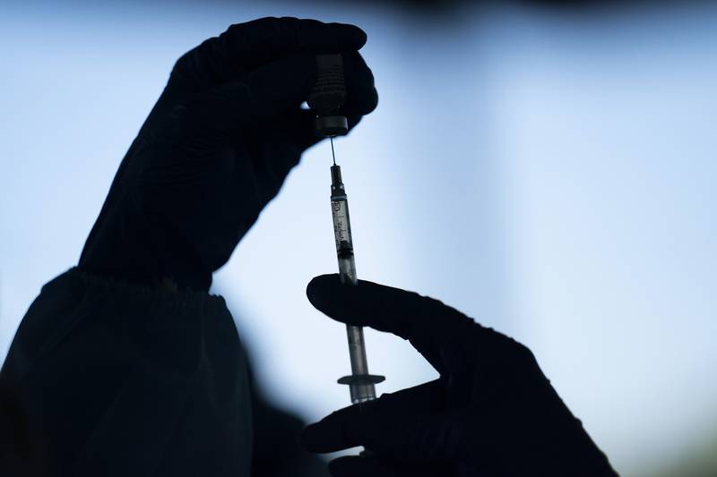 FILE - A medical staff member prepares the Pfizer-BioNTech COVID-19 vaccine at Tudor Ranch in Mecca, Calif. on Jan. 21, 2021.