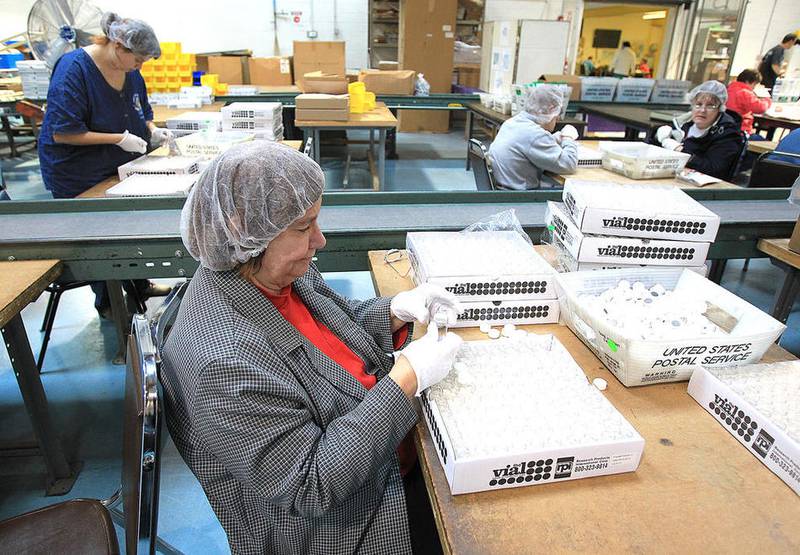 Pioneer Center clients assemble plastic bottles while working at the Pioneer Center for Human Services in McHenry in 2012. (Northwest Herald file photo)