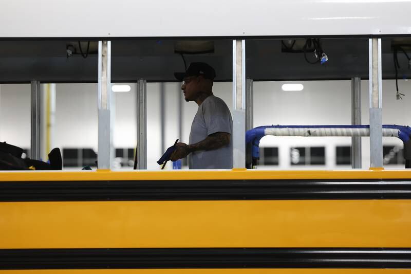 A worker walks through the shell of a bus being assembled at the Lion Electric manufacturing facility on Friday, July 21st, 2023 in Joliet.
