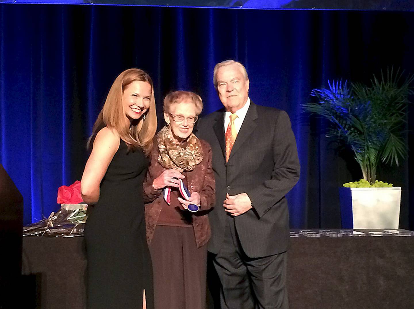 Billie Limacher of Joliet receives the Lincoln Award from Illinois State Travel Director Jan Hoelzle and Bill Kurtis.