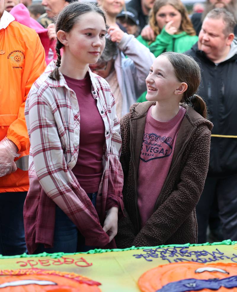 Allison Vavra (left) and Finley McDonald, honorable mention winners in the theme contest, chat as they wait for the cake cutting Wednesday, Oct. 25, 2023, on North Maple Street adjacent to the DeKalb County Courthouse during the Sycamore Pumpkin Festival.