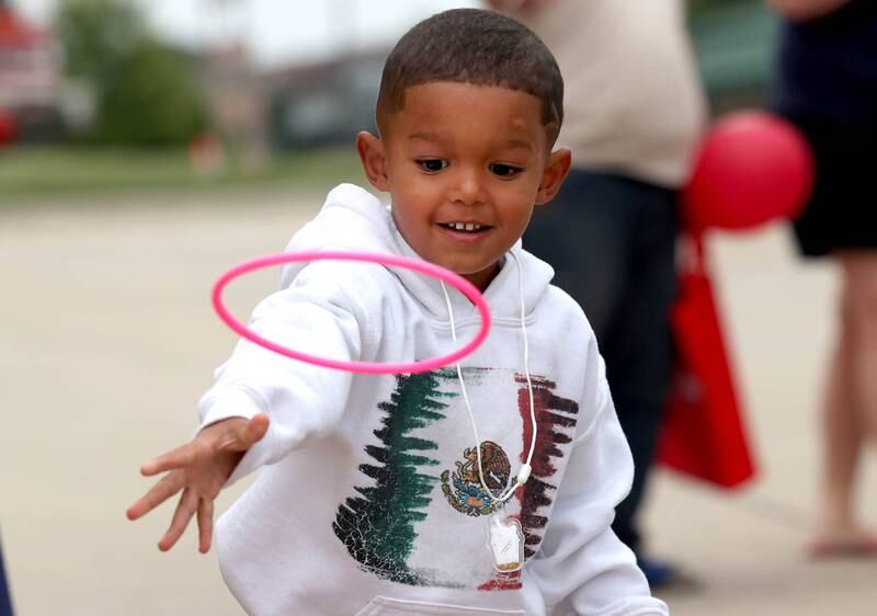 Marcus McKinney, 3, from DeKalb, tries his hand at the ring toss at the First Student booth Tuesday, Aug. 6, 2024, during National Night Out in the Hy-Vee parking lot in Sycamore.