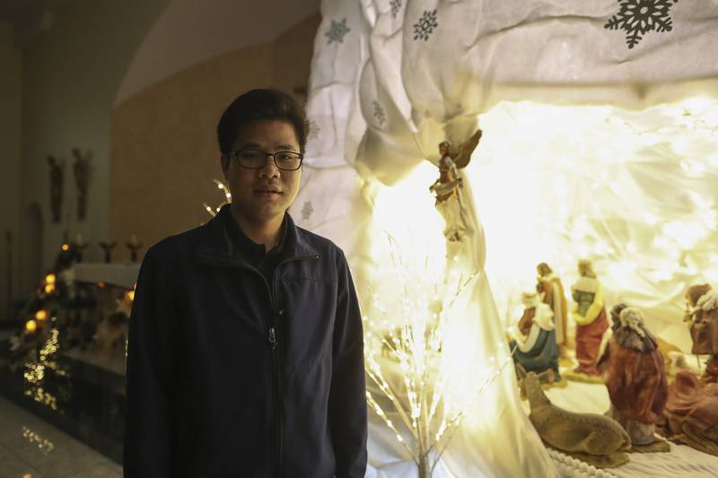 Seminarian Peter Nguyen poses for a portrait on Thursday, Jan. 7, 2021, at Saint Anthony Catholic Church in Joliet, Ill. Nguyen helped build a holiday nativity display in the church sanctuary, which will remain up until mid-January.