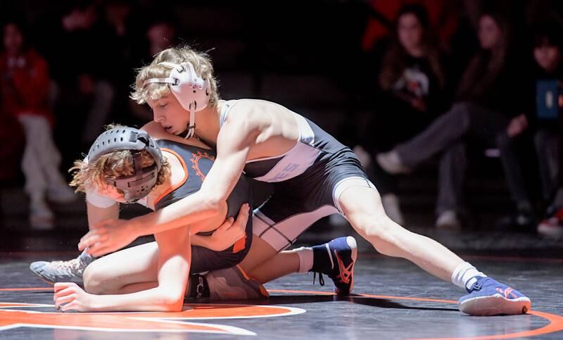 Marian Central's Austin Hagevold, top, and St. Charles East's Kaden Potter wrestle at 106 pounds during a match in St. Charles on Wednesday, December 20, 2023.