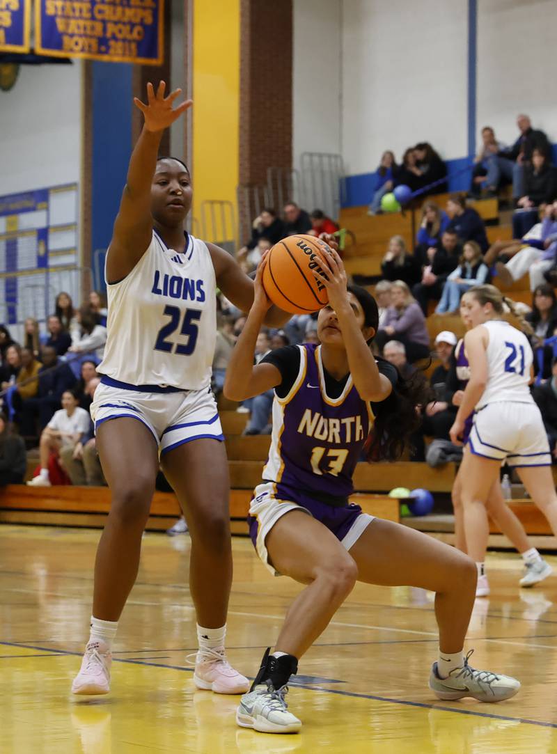 Downers Grove North's Urja Shah (13) tries to get past Lyons' Nora Ezike (25) during the girls varsity basketball game between Downers Grove North and Lyons Township on Saturday, Jan. 11, 2025 in La Grange.