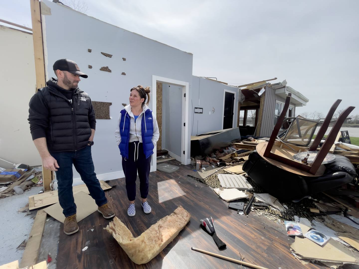 Dave Herberger and his wife, Emily LaVoie, stand in what was their game room at their Elmwood Drive home in Aroma Township on April 8, 2026. The couple took shelter in their basement when the tornado tore through their subdivision on March 10, 2026.
