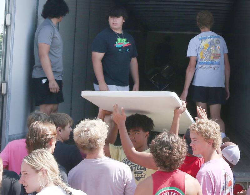Students from La Salle-Peru Township High School and St. Bede Academy help unload desks, tables and other furniture out of a semi provided by the Illinois Valley Community College Truck Driver Training Program into the new Lighted Way building in the former Heritage Health nursing home on Tuesday, July 11, 2023 in La Salle. Lighted Way reached out to the area schools to help move the supplies from the old building to the new one.