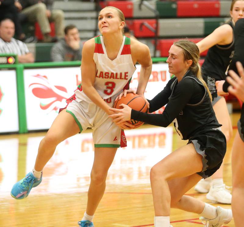 L-P's Kaylee Abens runs in the lane as Kaneland's Alexis Schueler forces a jump ball on Friday, Dec. 8, 2023 in Sellett Gymnasium at L-P High School.