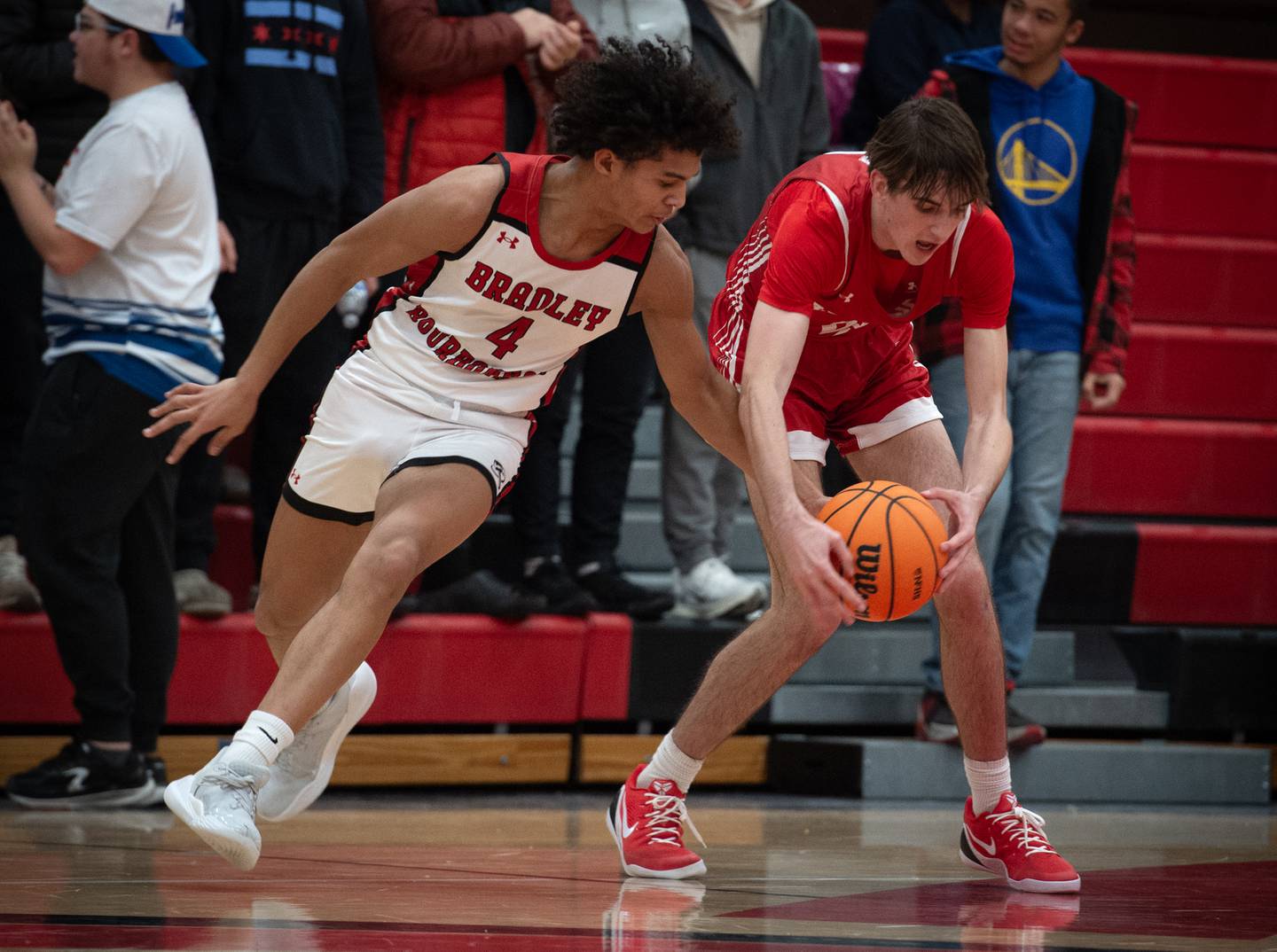 Bradley-Bourbonnais's DaJaun Brown, left, knocks the ball away from Naperville Central's Nathan Abrahamson in a game on Monday, December 15, 2025.