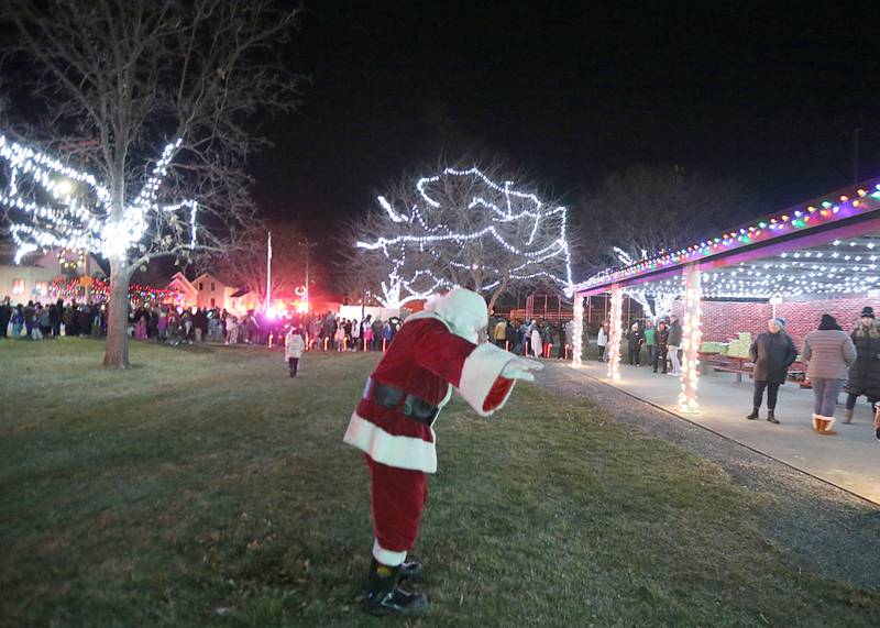 Santa waves to children as he arrives to Washington Park during the Light up the Night parade on Saturday, Dec. 3, 2022 at Washington Park in Peru.