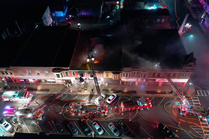 An aerial view shows firefighters battling an apartment fire in the second story at 708 Illinois Avenue on Friday, Dec. 30, 2022 downtown Mendota.