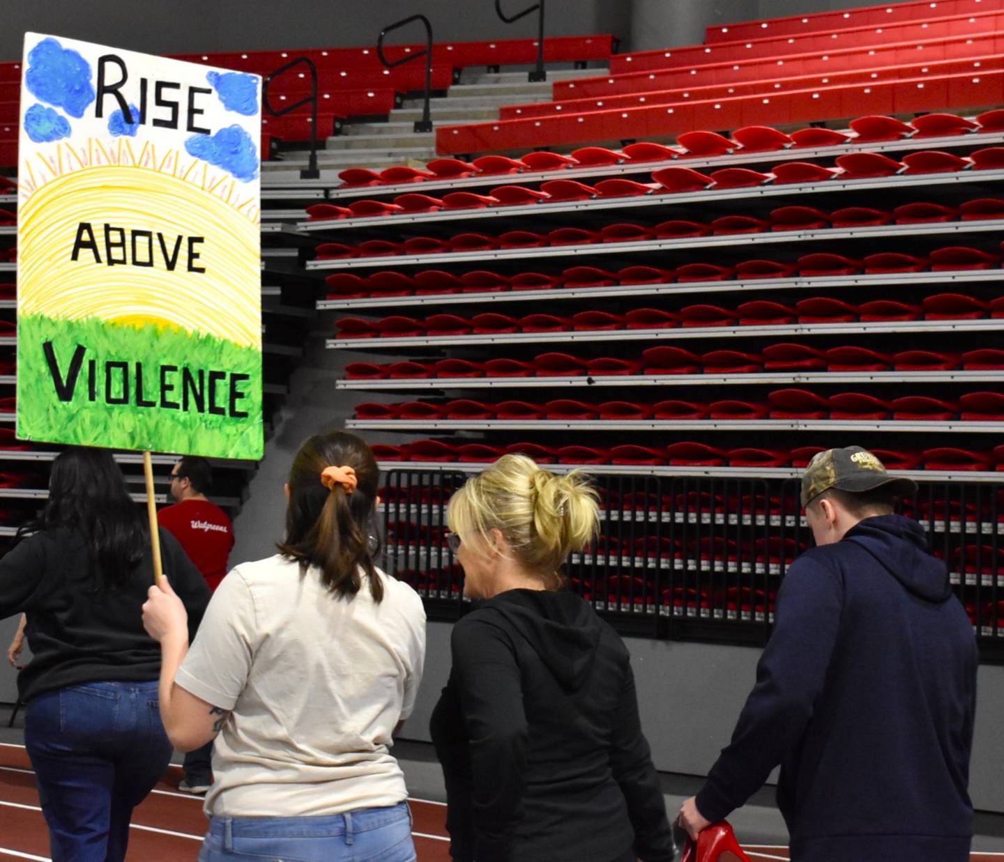 Participants in Safe Passage's annual Walk A Mile in Their Shoes event hold signs to raise awareness about domestic violence and abuse in DeKalb County. (Event from 2025). The event returns to DeKalb on April 18, 2026.