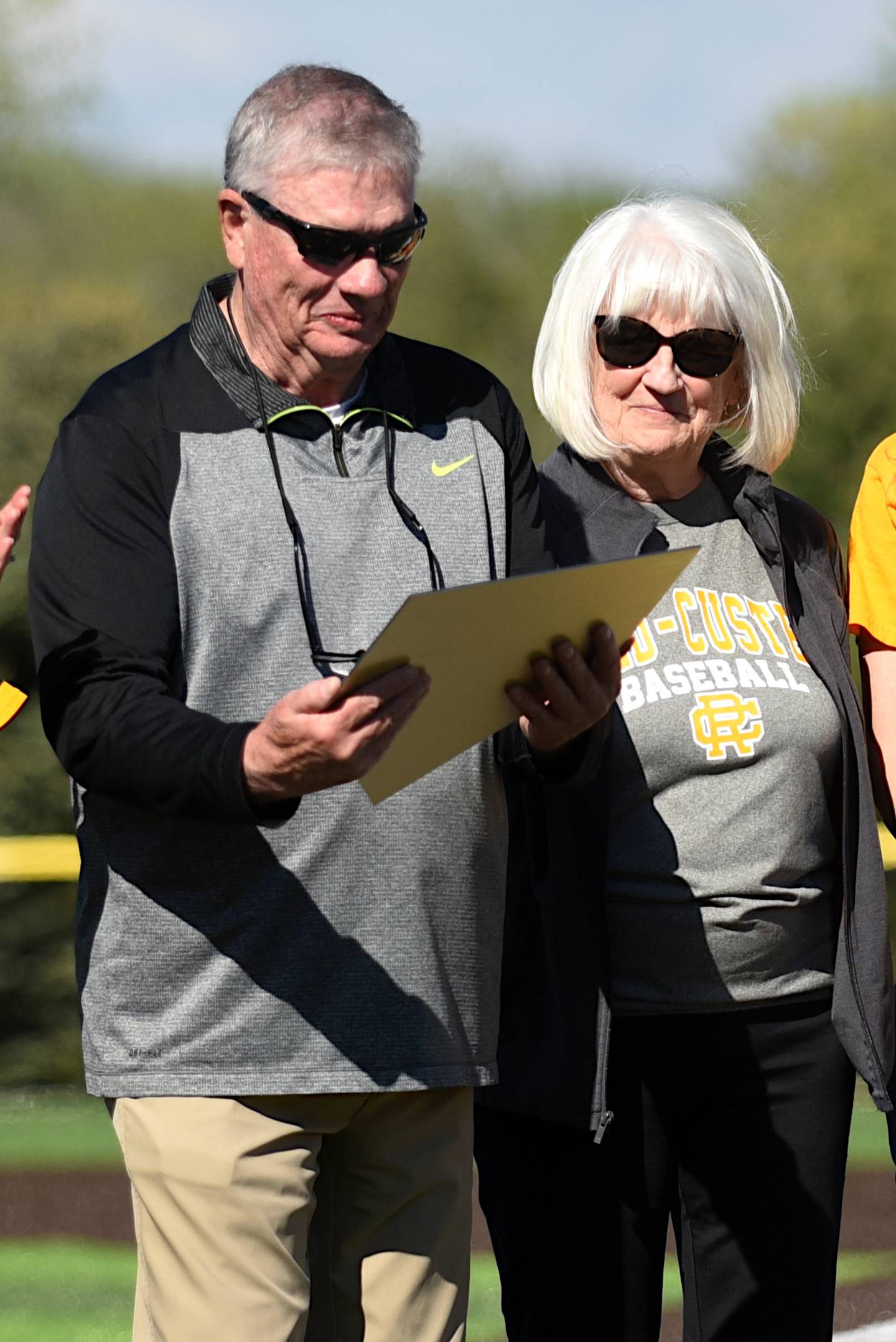 Retired Reed-Custer baseball coach Jerry Cougill, left, and his wife, Kay, admire the replica of a bronze home plate recognizing him during a ceremony ahead of a game against Coal City Tuesday, May 6, 2025.