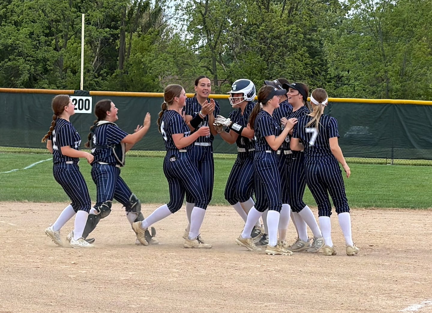 Cary-Grove's Emily Glen is greeted by teammates after hitting a walk-off single to beat Harvard 5-4 in a Class 3A Prairie Ridge Regional semifinal on Tuesday, May 19, 2026, in Crystal Lake.